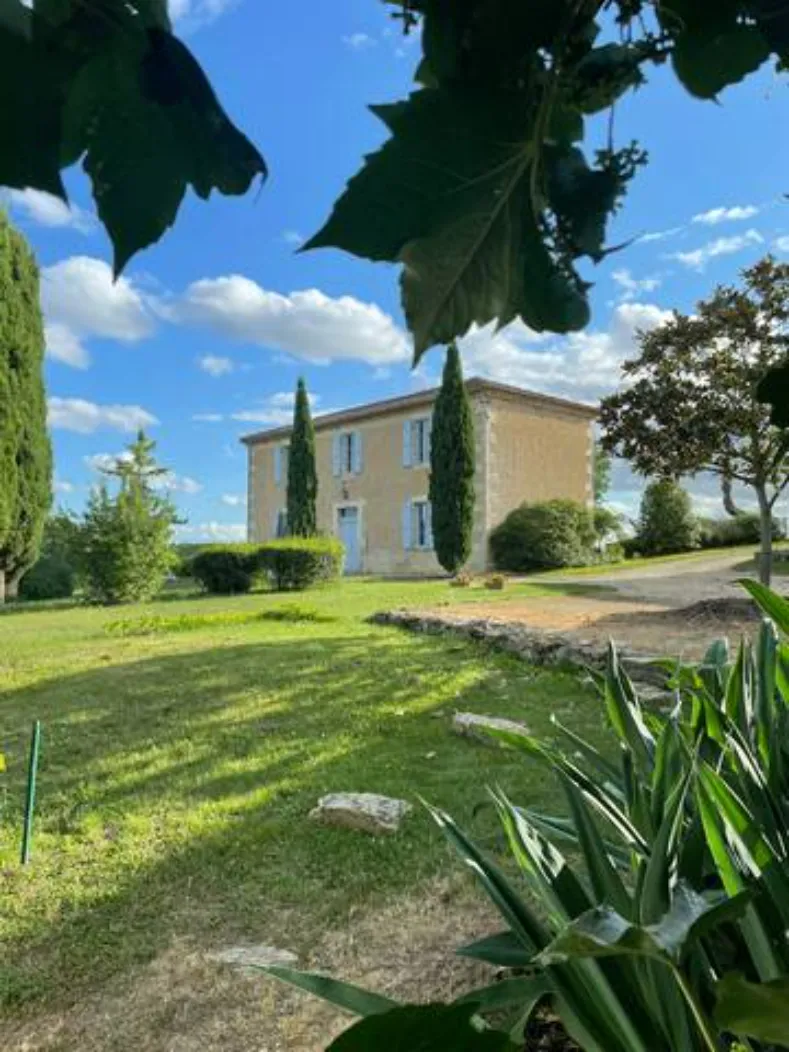 Façade de la grande maison gasconne, pierre et volets bleus