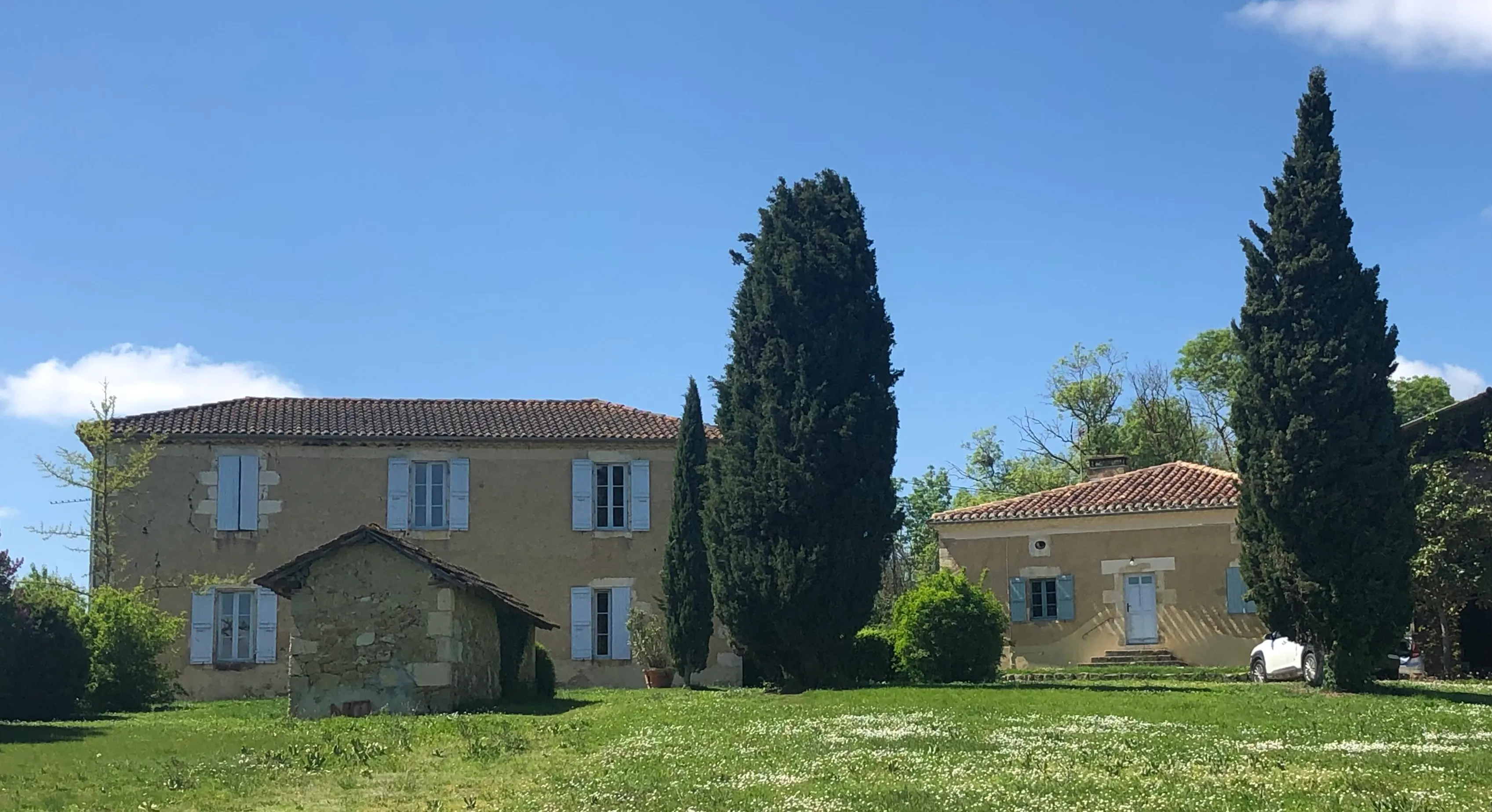 Les deux maisons gasconnes en pierre, entourées de cyprès, à Préchac dans le Gers