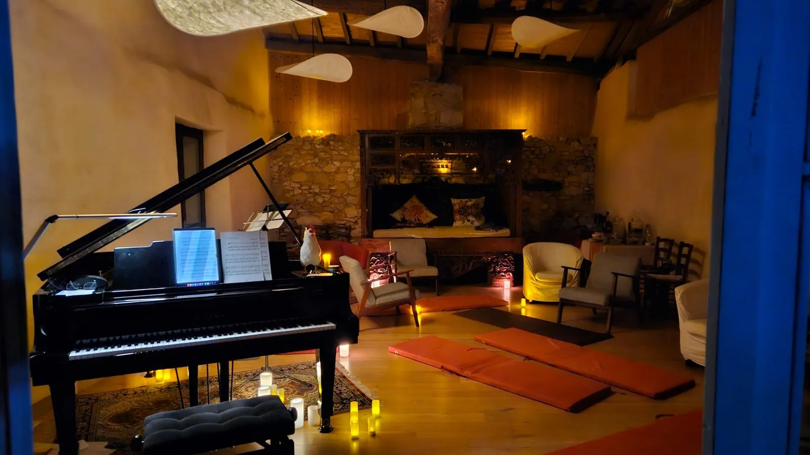Salle de musique de la petite maison, piano à queue éclairé aux bougies le soir